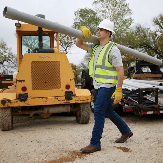 A construction worker wearing Justin Work boots on a job site